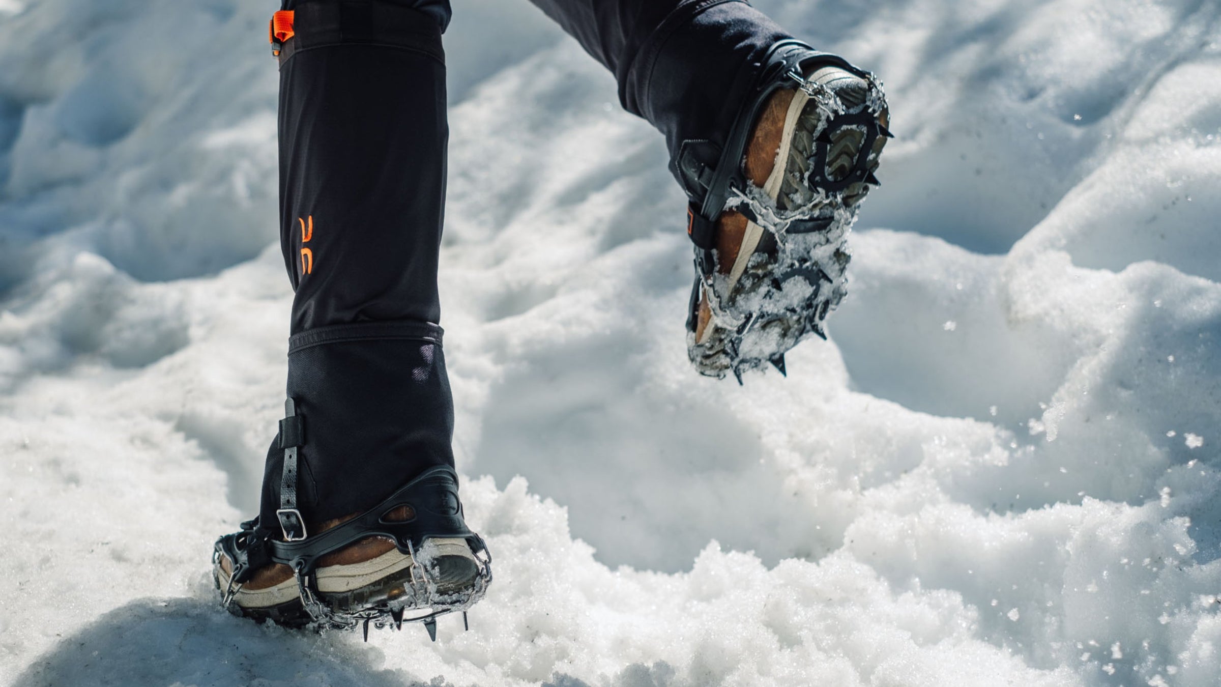Someone running through snow wearing crampons